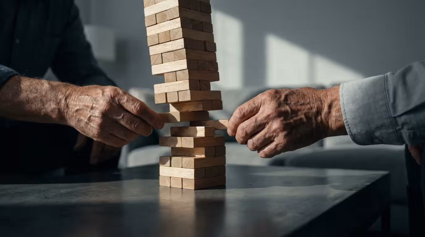 Low angle view of senior hands carefully adjusting a teetering wooden block tower.